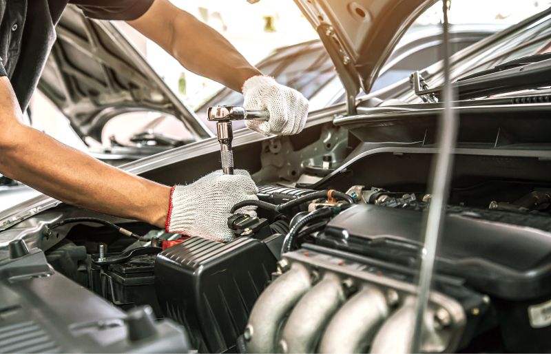 Kfz-Mechaniker mit Schraubenschlüsseln in der Hand
