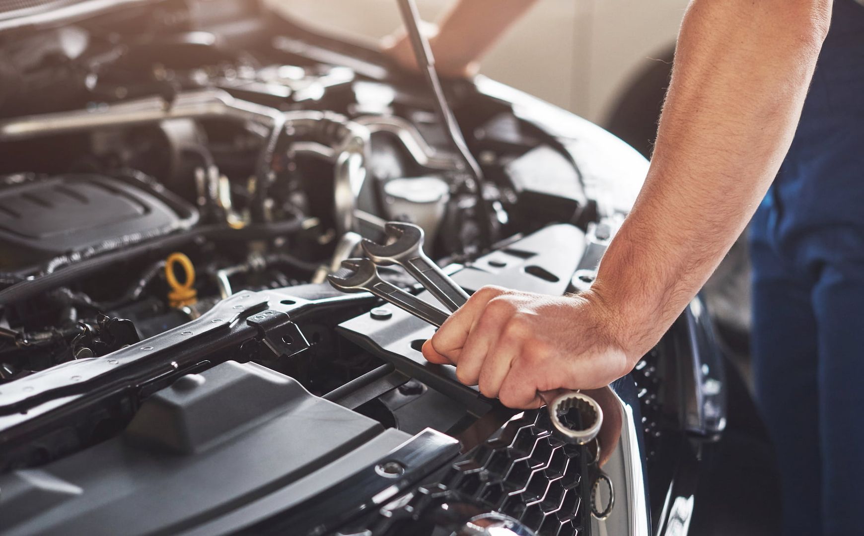 Kfz-Mechaniker mit Schraubenschlüsseln in der Hand